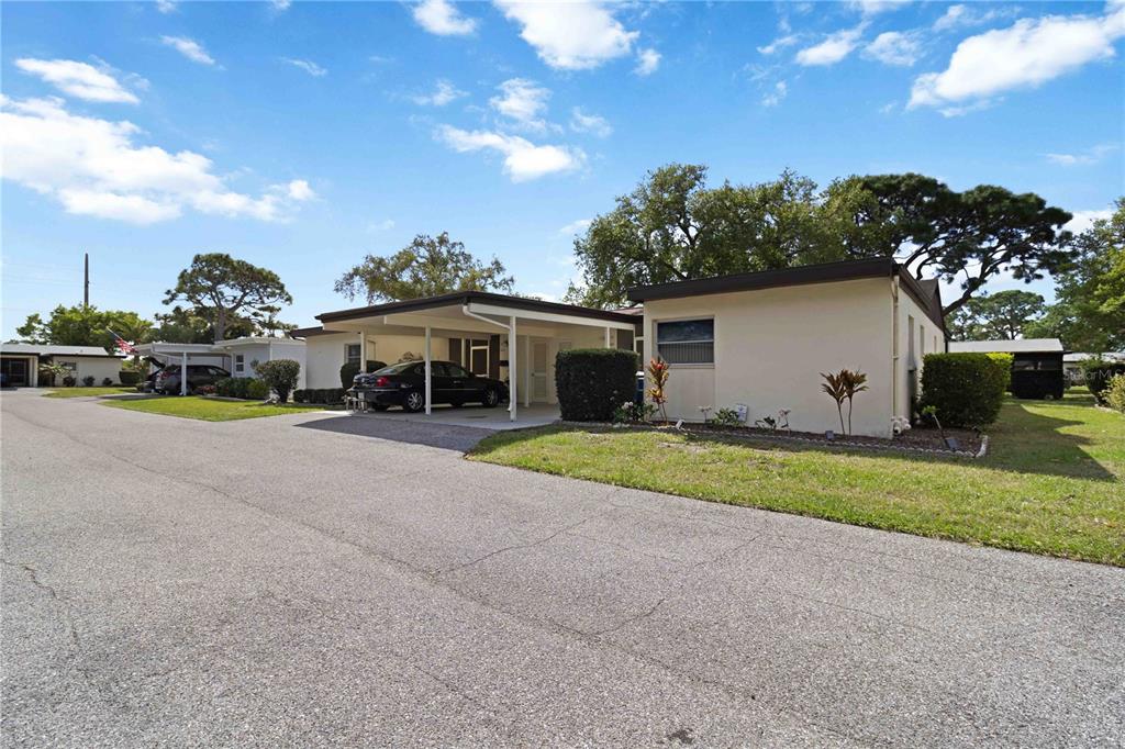 A single-story house with a carport and a paved driveway under a blue sky — 6215 GREEN VIEW CIRCLE UNIT 74, SARASOTA, FL
