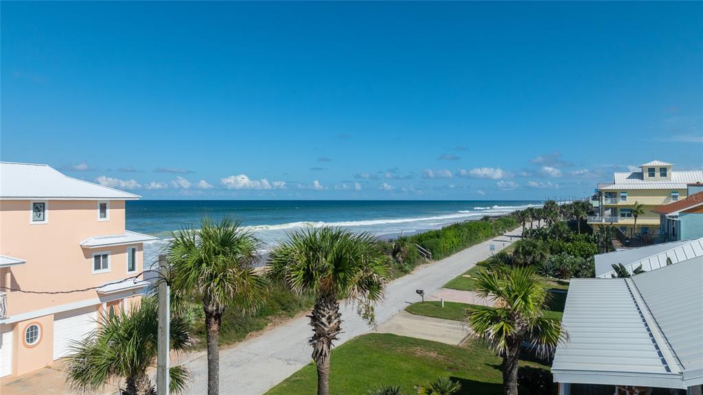 An elevated view of a beachside road, palm trees, and houses near the ocean — 6000 S ATLANTIC AVENUE, NEW SMYRNA BEACH, FL