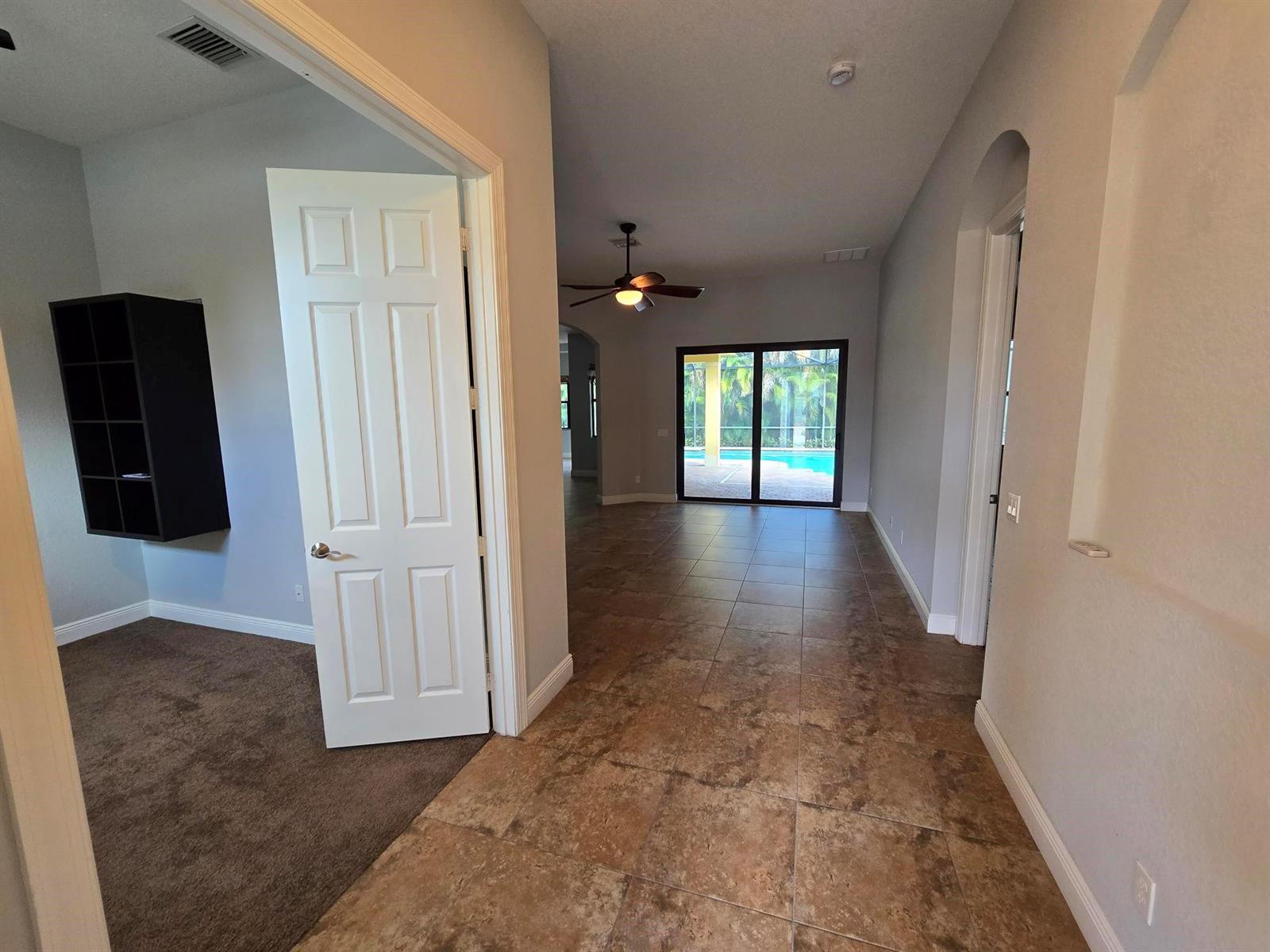 A view from a tiled hallway looking into a room with a pool view — 2095 NW Diamond Creek Way, Jensen Beach FL 34957, JENSEN BEACH, FL