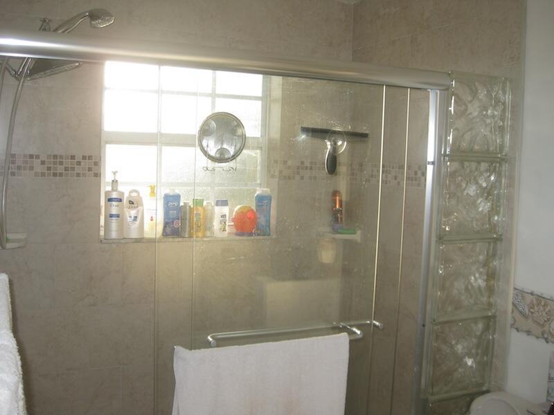 A tiled shower stall features a glass sliding door, a window, and glass block accents — 4070 NW 91st Terrace, Sunrise FL 33351, SUNRISE, FL