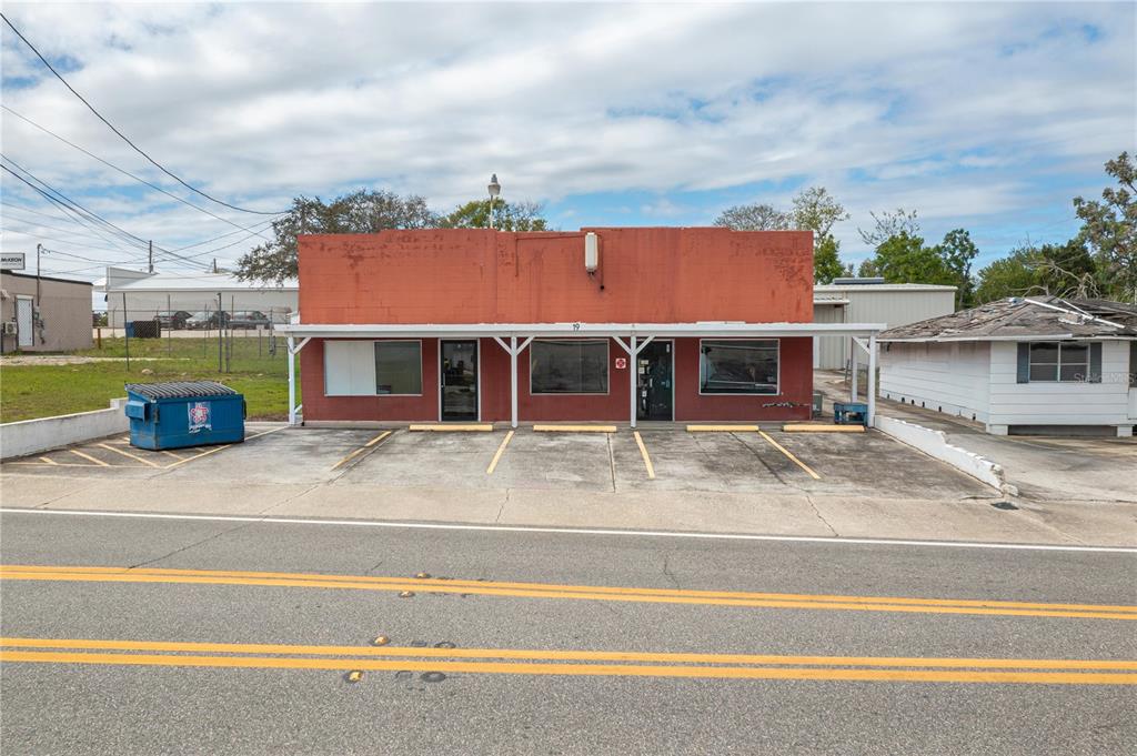 A single-story red commercial building with a front parking lot and a covered walkway — 19 EVERGREEN DRIVE, LAKE WALES, FL
