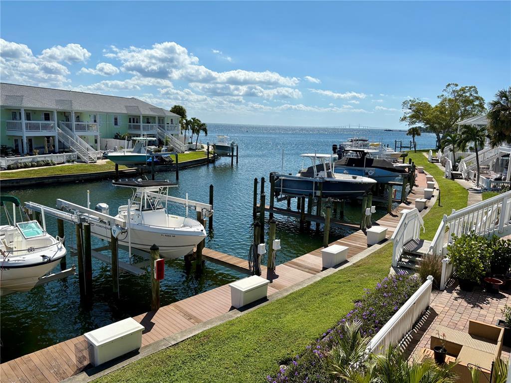 A view of a canal with several boats docked at private lifts near waterfront homes — 5184 BEACH DRIVE SE UNIT D, ST PETERSBURG, FL