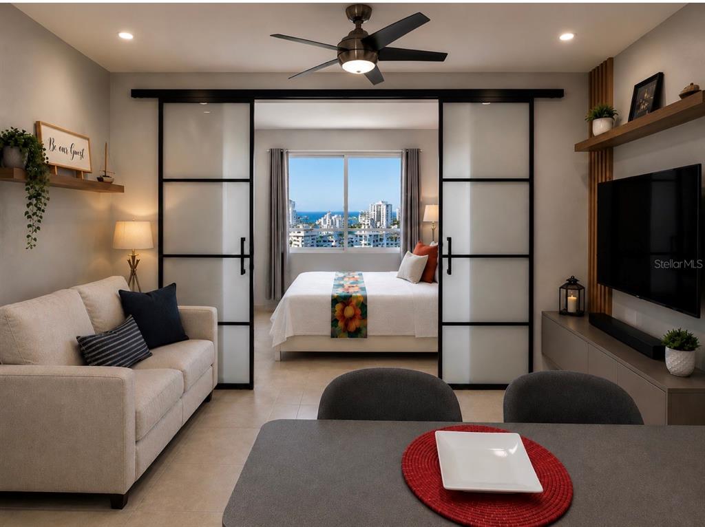 A living room with a sofa and dining table opens to a bedroom with ocean views — 602 Ave Fernandez Juncos COND. SEA VIEW UNIT 1704, SAN JUAN, PR