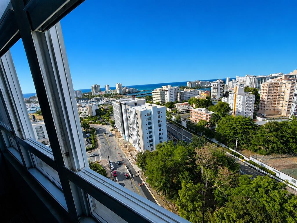 An elevated view from a window overlooking a city street, buildings, and the ocean — 602 Ave Fernandez Juncos COND. SEA VIEW UNIT 1704, SAN JUAN, PR