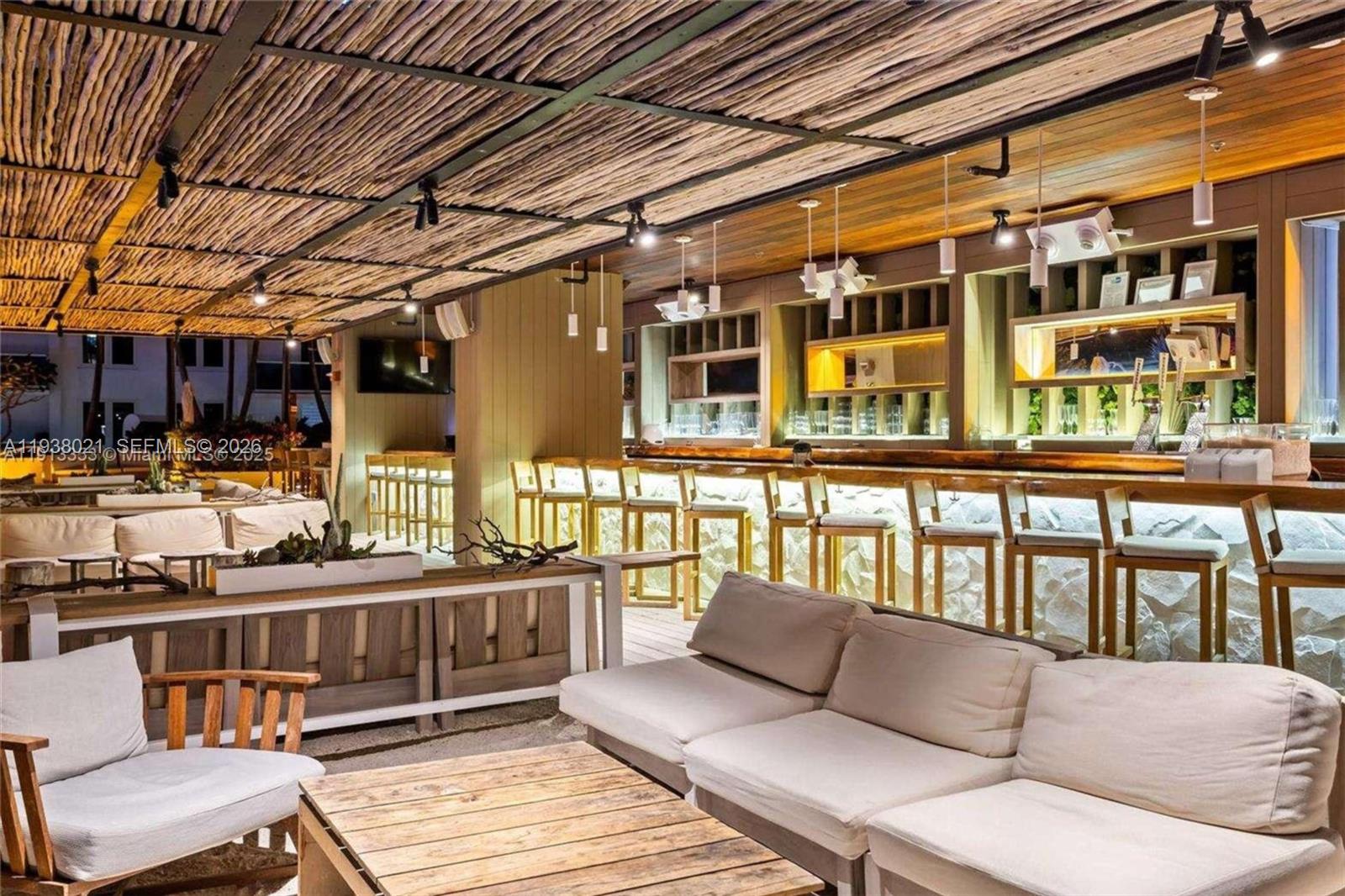 An outdoor bar area features a rustic wood-slat ceiling, stone-faced bar, and lounge seating — 2301 Collins Ave # 423, Miami Beach FL 33139, MIAMI BEACH, FL
