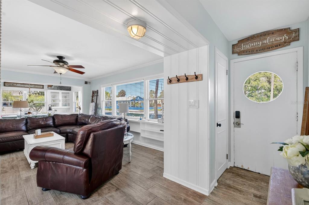 A living room features a brown leather sectional, wood-look tile flooring, and a white front door — 731 N OLEANDER AVENUE, DAYTONA BEACH, FL