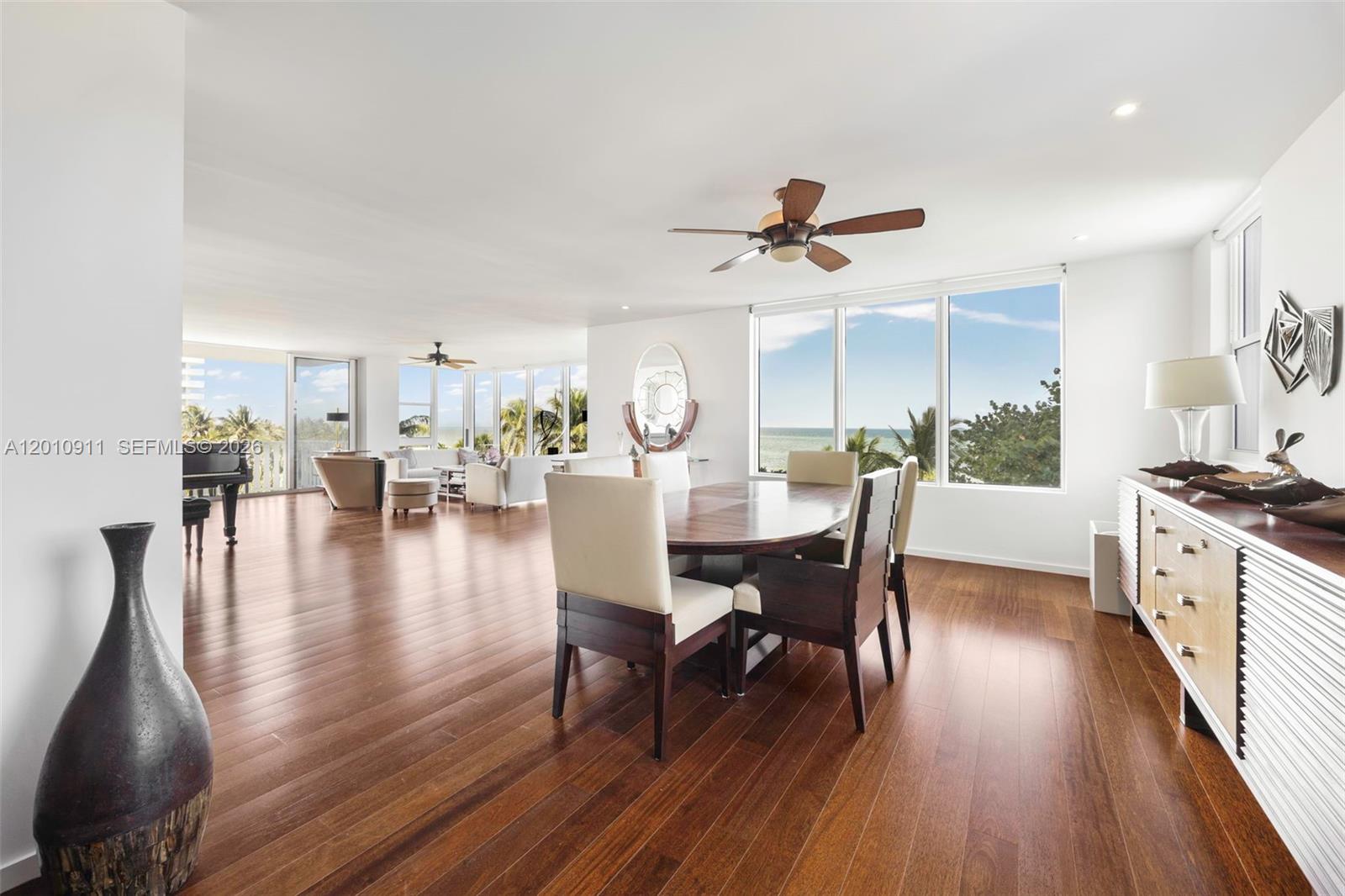 A dining area and living space feature hardwood floors, large windows, and ocean views — 200 Ocean Lane Dr # 401, Key Biscayne FL 33149, KEY BISCAYNE, FL