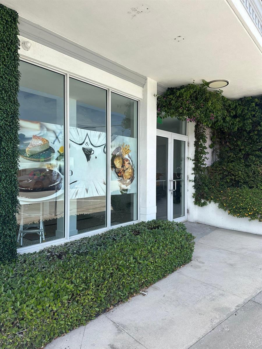 The exterior of a commercial building features large glass windows with food decals and greenery — 5505 S Dixie Highway # 4, West Palm Beach FL 33405, WEST PALM BEACH, FL