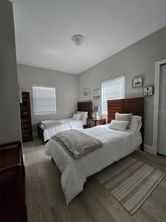 A bedroom features two twin beds, wood-toned headboards, light-colored flooring, and two windows with blinds — 244 LEXINGTON DRIVE, DAYTONA BEACH, FL