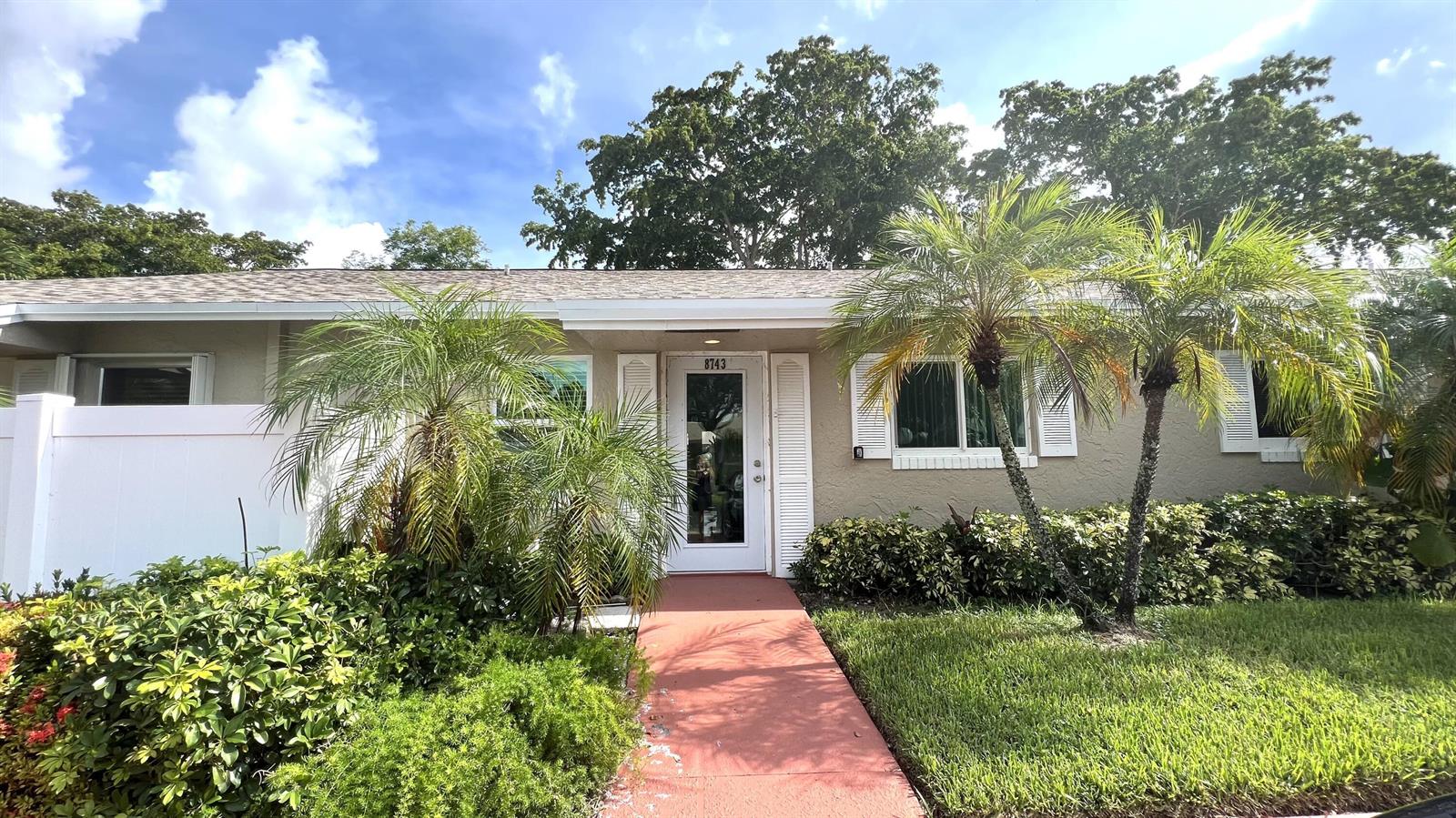 A single-story house with a red walkway, palm trees, and white shutters — 8743 Rheims Road # B, Boca Raton FL 33496, BOCA RATON, FL