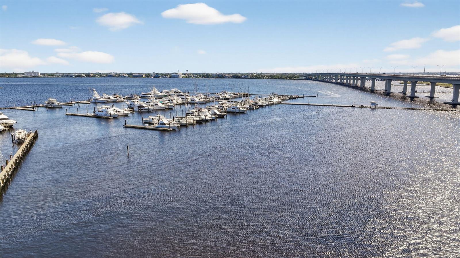 An aerial view shows a marina filled with boats next to a long bridge — 875 NW Flagler Avenue # 302, Stuart FL 34994, STUART, FL