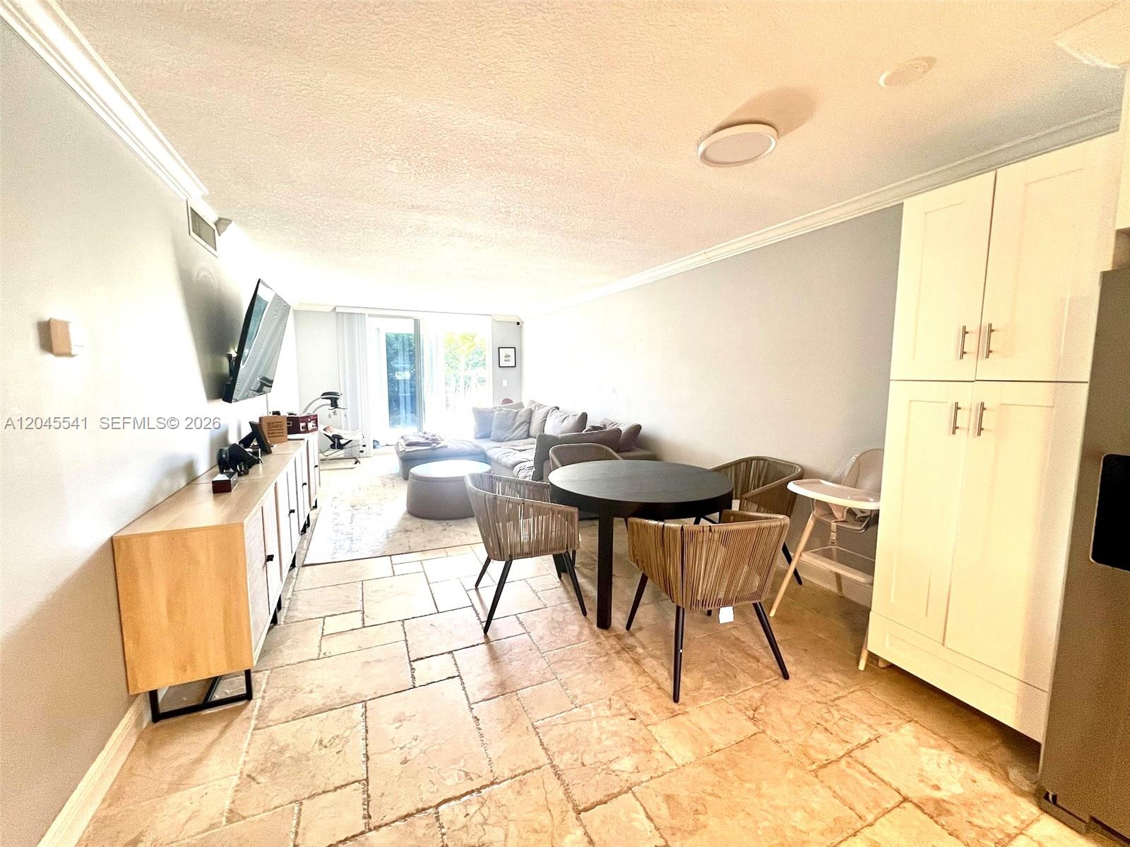 A living and dining area features tile flooring, a round table, and a sectional sofa — 689 NE 6th Ct # 1080, Boynton Beach FL 33435, BOYNTON BEACH, FL