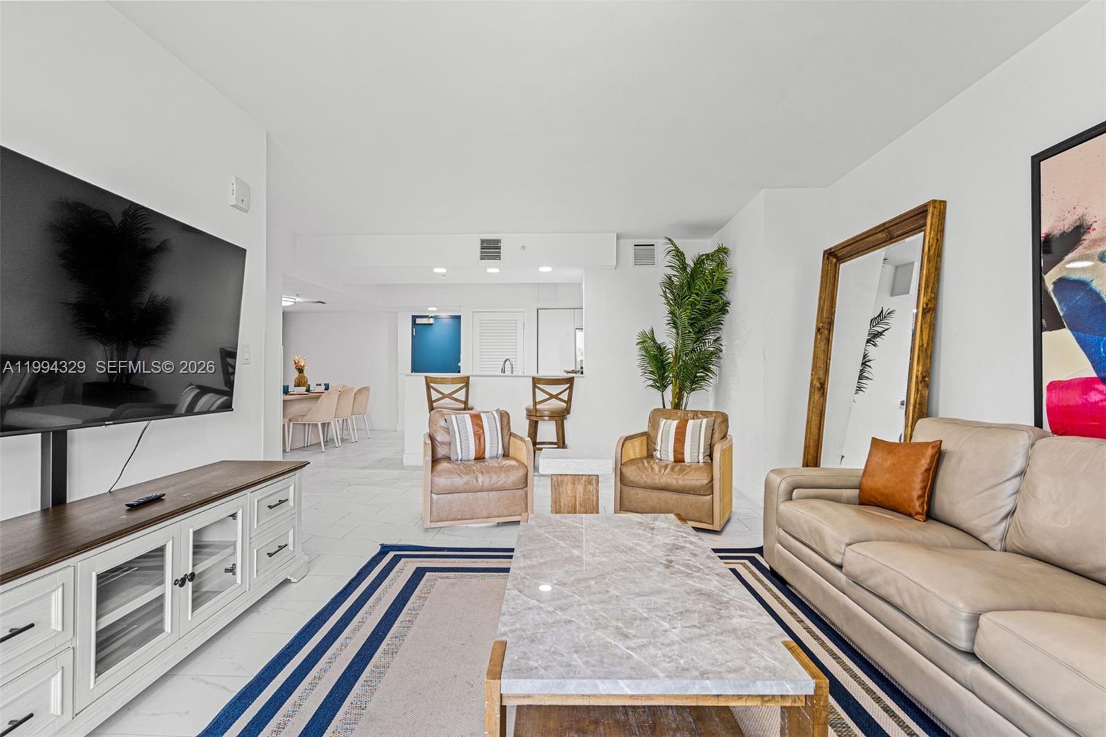 A living room features a marble coffee table, leather sofa, two armchairs, and a television — 1850 Monroe St # 310, Hollywood FL 33020, HOLLYWOOD, FL