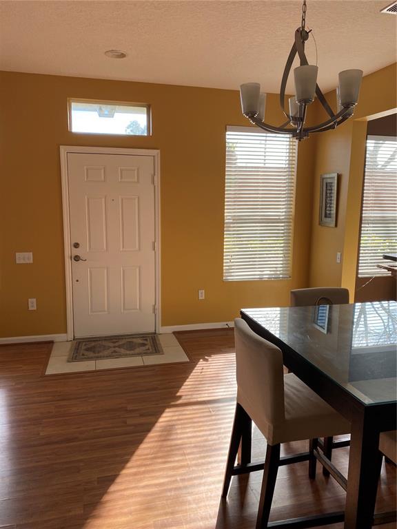 A dining area features a glass-topped table, a chandelier, and a white front door — 2632 GALLIANO CIRCLE, WINTER PARK, FL