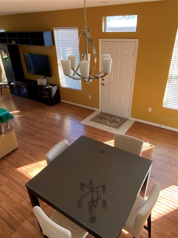 A dining area with a dark square table and chandelier sits before a living room — 2632 GALLIANO CIRCLE, WINTER PARK, FL
