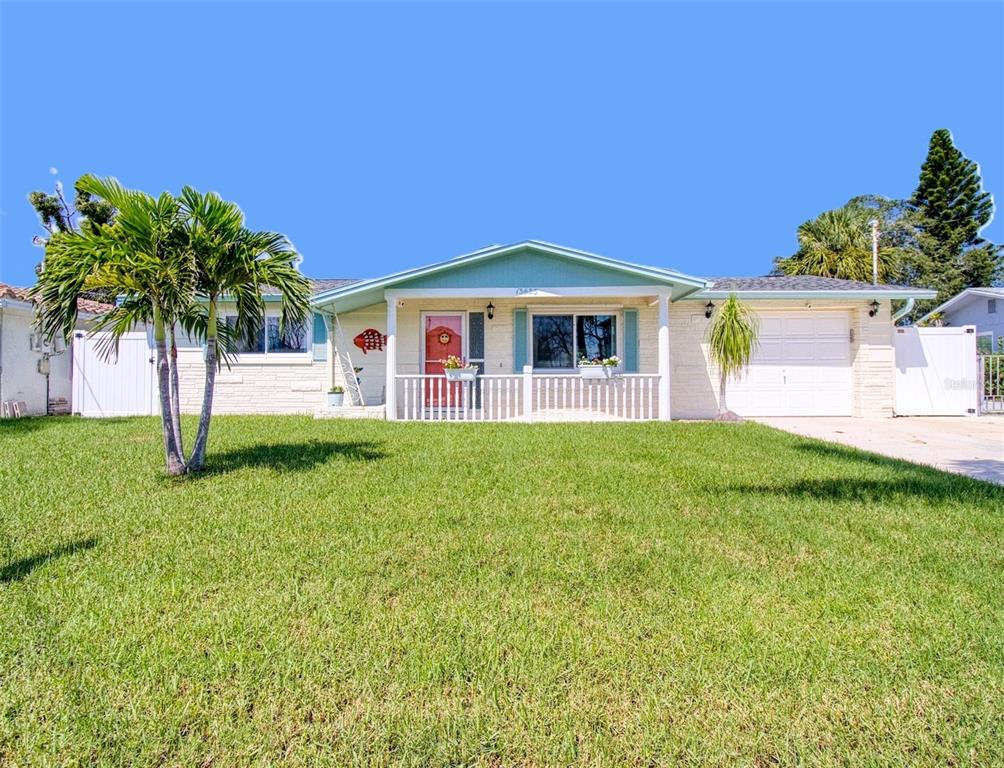 An aerial view shows a residential house with a gray roof along a canal — 13625 MARIA DRIVE, HUDSON, FL