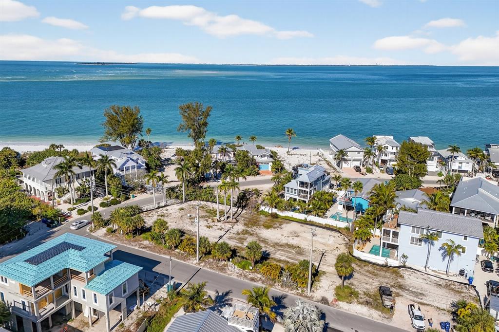 An aerial view shows a vacant coastal lot surrounded by houses near the ocean — 812 N BAY BOULEVARD, ANNA MARIA, FL