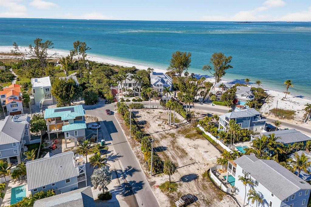 An aerial view shows a vacant coastal lot situated between residential homes near the beach — 812 N BAY BOULEVARD, ANNA MARIA, FL