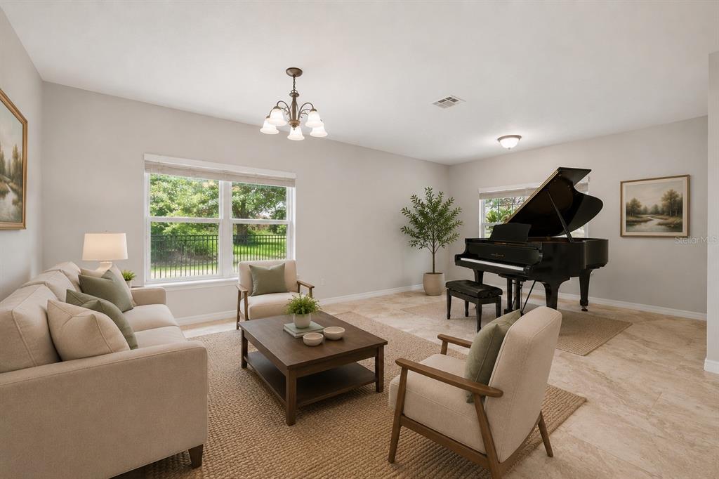 A living room features a grand piano, beige sofa, two armchairs, and tile flooring — 921 BENDING OAK TRAIL, WINTER GARDEN, FL