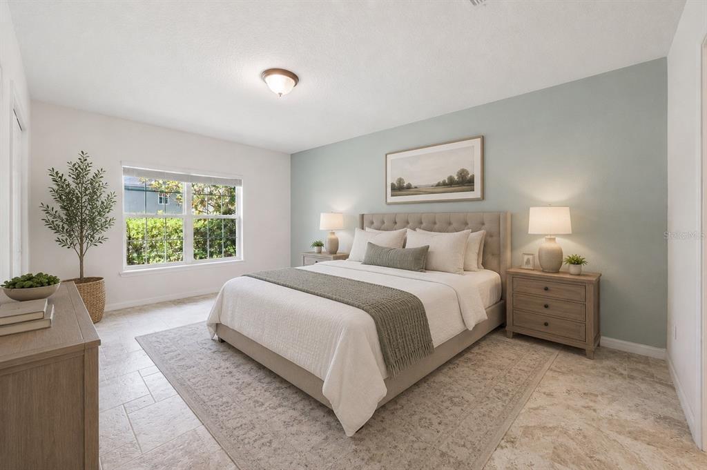 A bedroom features a tufted headboard, light blue accent wall, and tiled flooring — 921 BENDING OAK TRAIL, WINTER GARDEN, FL