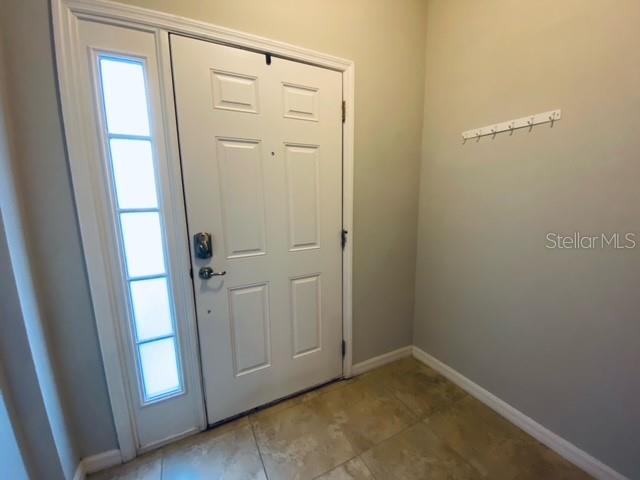 An entryway features a white front door with a side light and a wall-mounted coat rack — 6842 40TH LANE N, PINELLAS PARK, FL