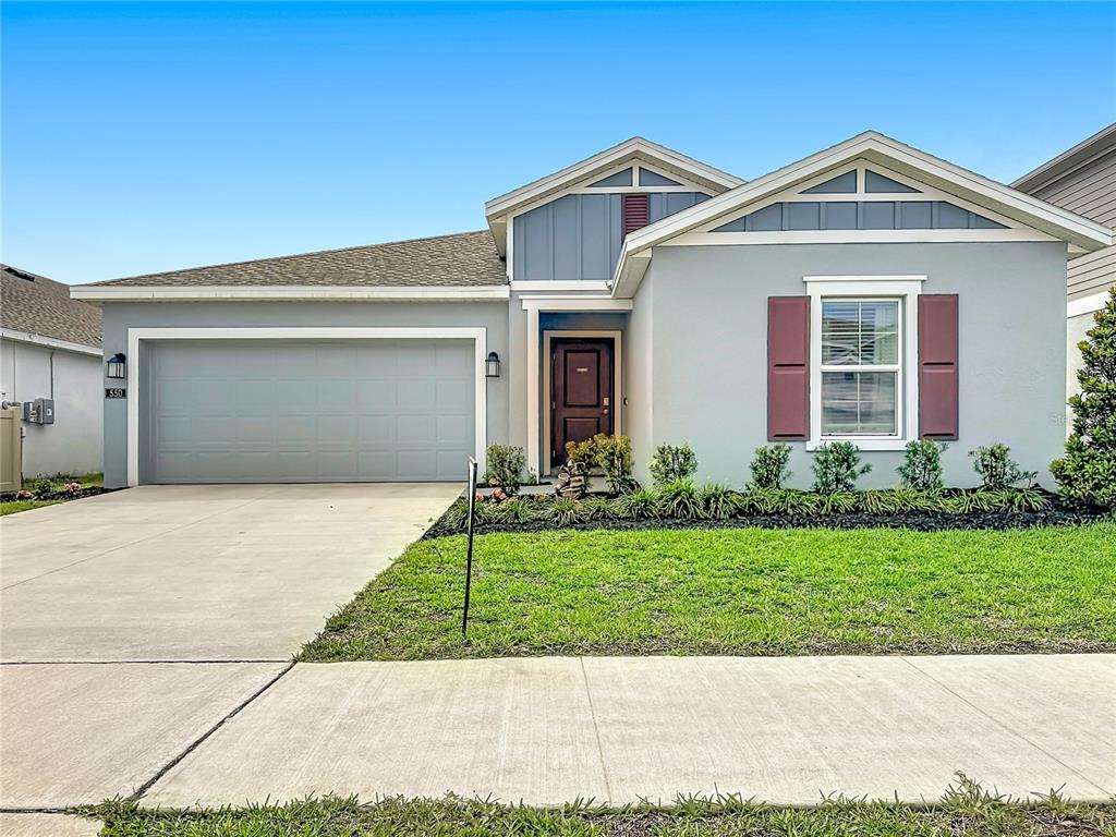 A single-story house with a gray exterior, a two-car garage, and red window shutters — 550 SEA TURTLE LANE, HAINES CITY, FL