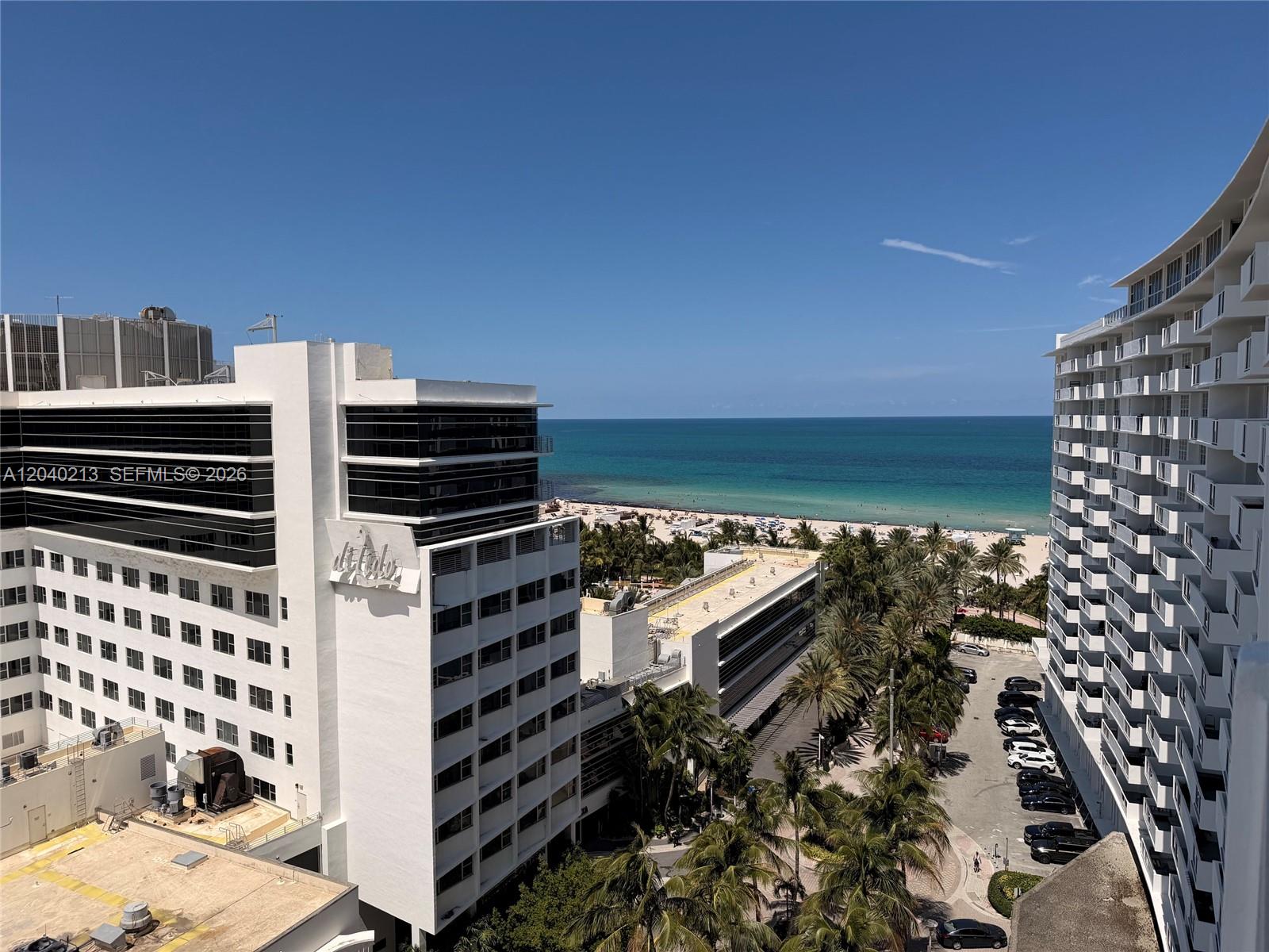 An elevated view shows two large white buildings flanking a parking lot and beach — 100 Lincoln Rd # 1410, Miami Beach FL 33139, MIAMI BEACH, FL