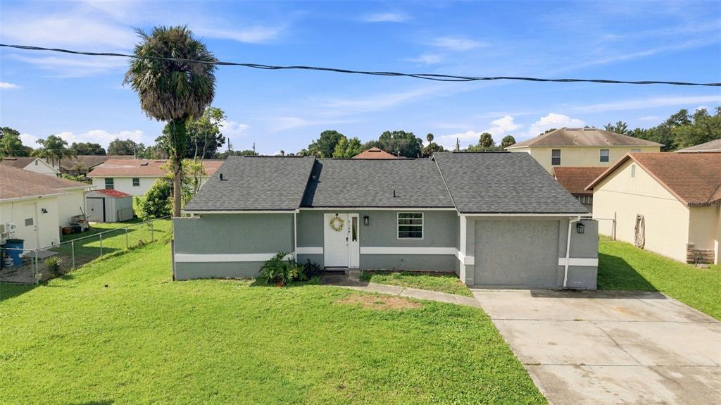 A single-story house with a gray exterior, a shingled roof, and an attached garage — 618 CARIBOU COURT, POINCIANA, FL