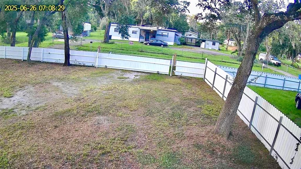 A large, grassy backyard features several mature trees and a white perimeter fence — 11310 BRIGHTRIDGE DRIVE, SEFFNER, FL
