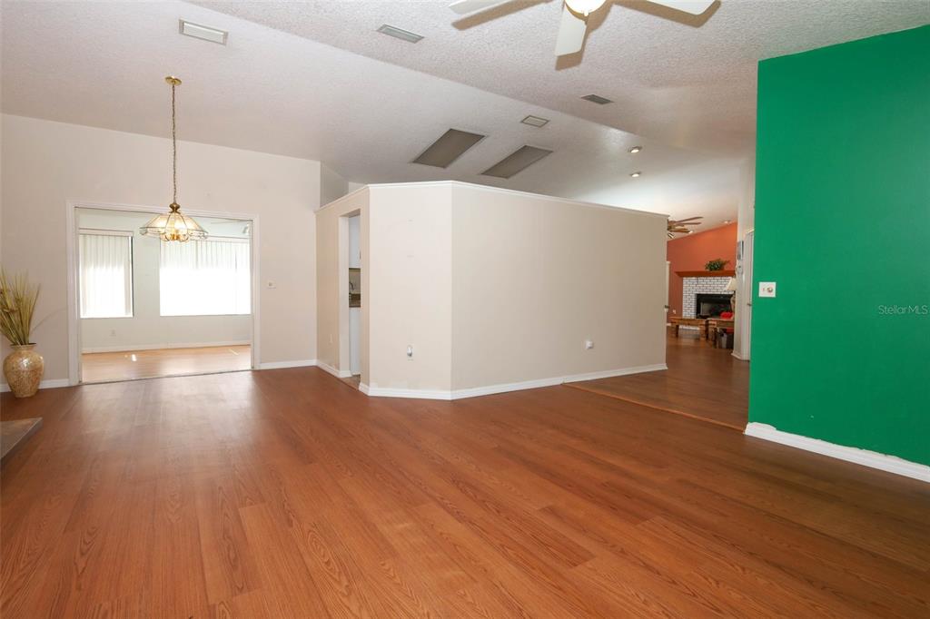 A living area features wood-look flooring, a green accent wall, and a central partition wall — 610 YORKTOWN DRIVE, LEESBURG, FL
