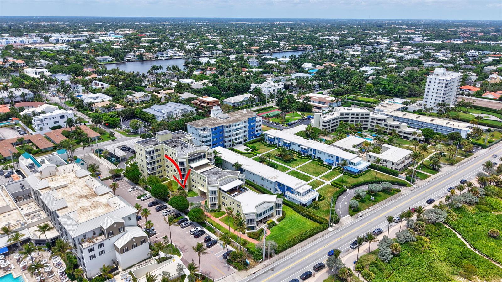 An aerial view shows a multi-story apartment complex with a parking lot and surrounding landscaping — 100 N Ocean Boulevard # 105, Delray Beach FL 33483, DELRAY BEACH, FL