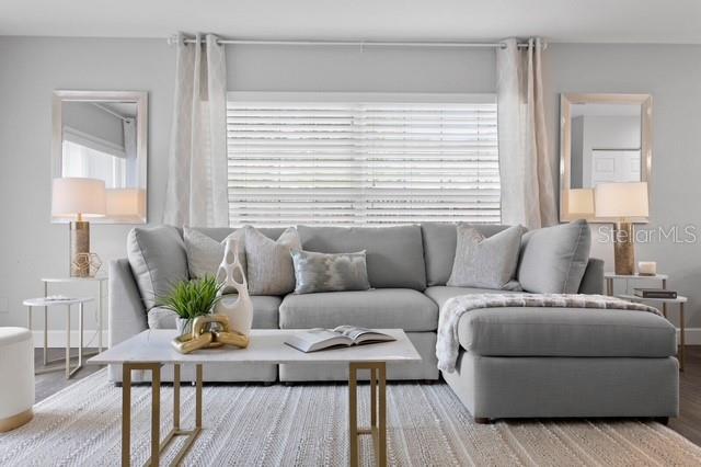 A living room features a light gray sectional sofa, a marble coffee table, and two mirrors — 14009 DOMINION COURT, TAMPA, FL
