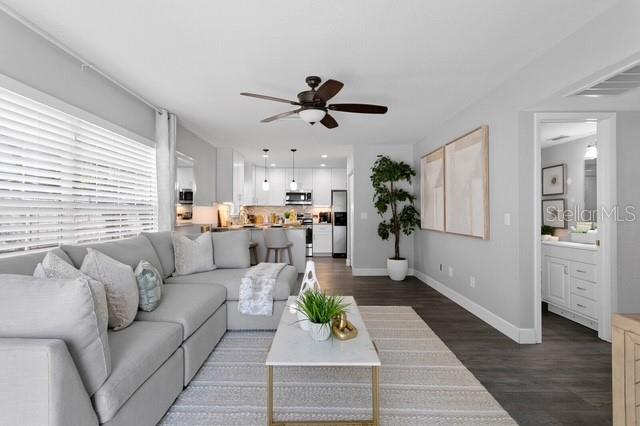 A living room with a gray sectional sofa, marble coffee table, and an open kitchen — 14009 DOMINION COURT, TAMPA, FL