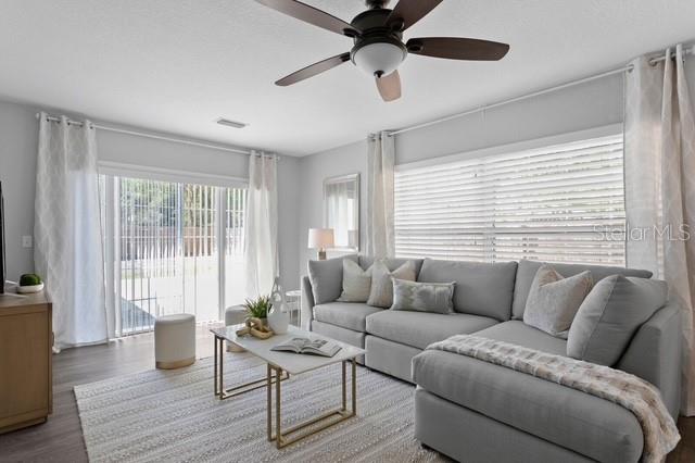 A living room features a gray sectional sofa, a marble coffee table, and a ceiling fan — 14009 DOMINION COURT, TAMPA, FL