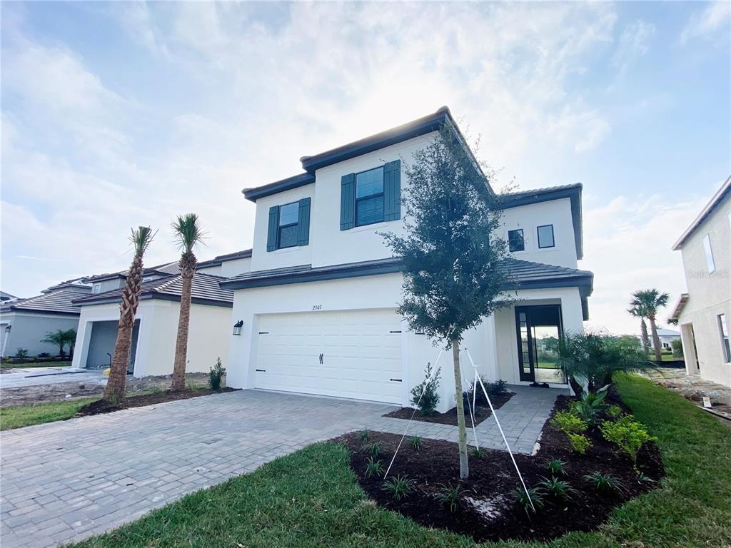 A two-story house with a white exterior, dark shutters, and a two-car garage — 2307 KESTREL PERCH PLACE, WINTER PARK, FL