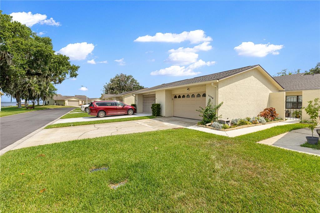 A tan single-story house with a two-car garage and a red minivan parked outside — 2226 CYPRESS COVE DRIVE UNIT 2226, TAVARES, FL