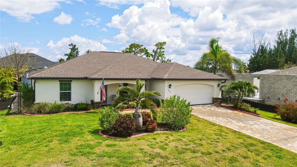 A wooden hot tub with a built-in bar and stools sits on a stone patio — 3233 NW 21ST STREET, CAPE CORAL, FL