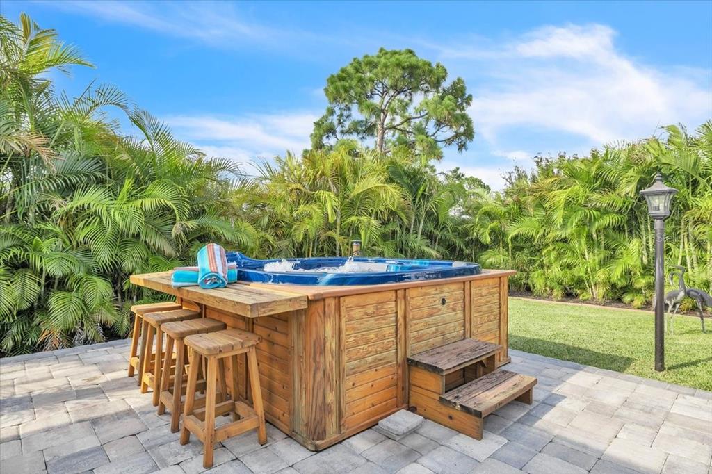 A wooden pavilion with a metal roof covers a dining set on a paved patio — 3233 NW 21ST STREET, CAPE CORAL, FL