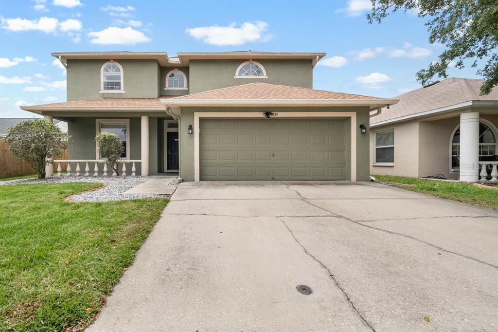 A two-story house with a green exterior, a two-car garage, and a concrete driveway — 9839 LAUREL LEDGE DRIVE, RIVERVIEW, FL