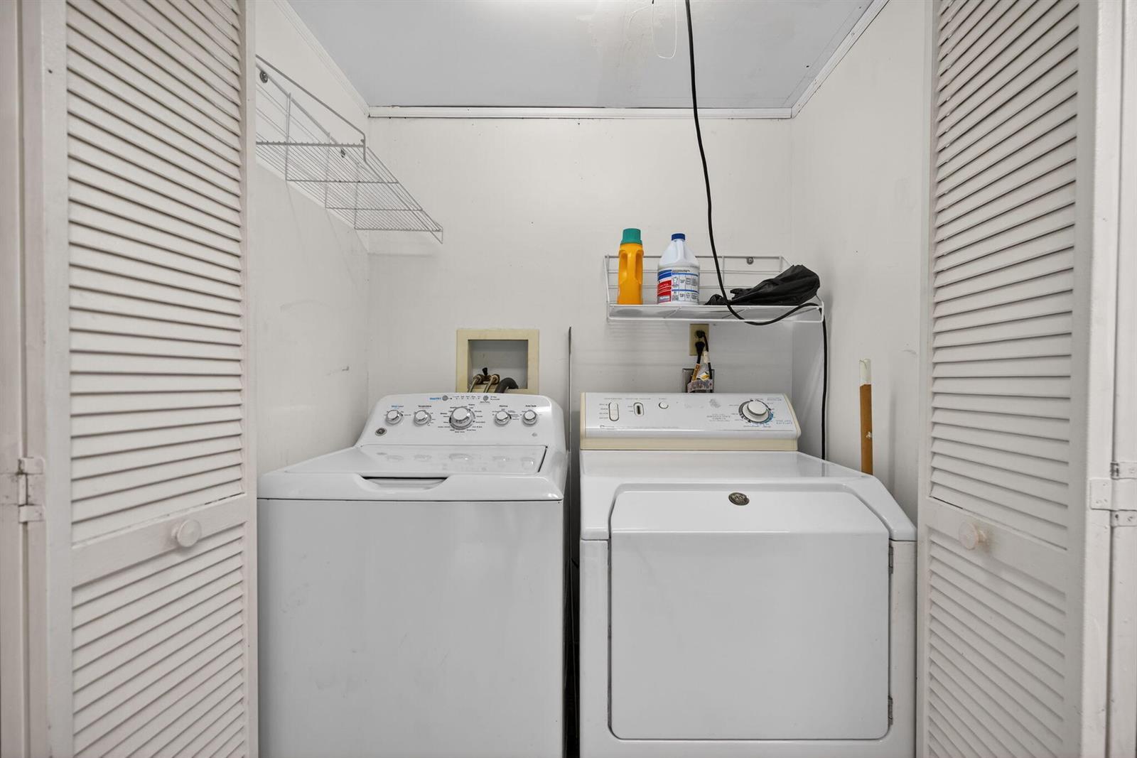 A laundry closet contains a white top-loading washing machine and a white dryer — 707 Stonewood Court # 19c, Jupiter FL 33458, JUPITER, FL