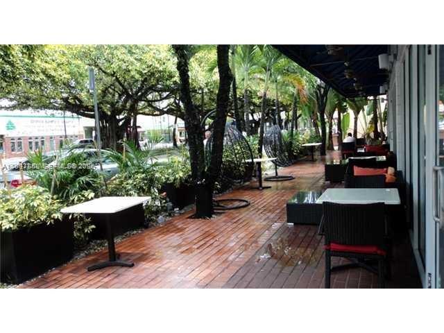 An outdoor restaurant patio features brick flooring, tables, chairs, and hanging egg chairs — 1777 SW 3 AV, Miami FL 33129, MIAMI, FL