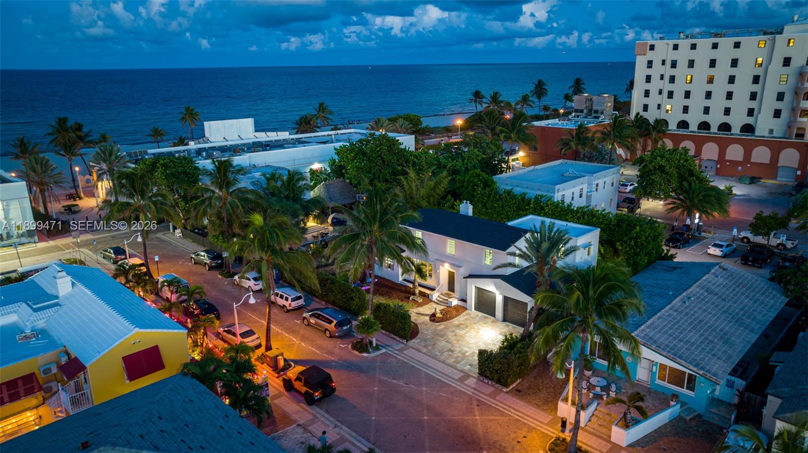 An aerial view shows a white house with a stone driveway near a beach — 320 Polk St, Hollywood FL 33019, HOLLYWOOD, FL