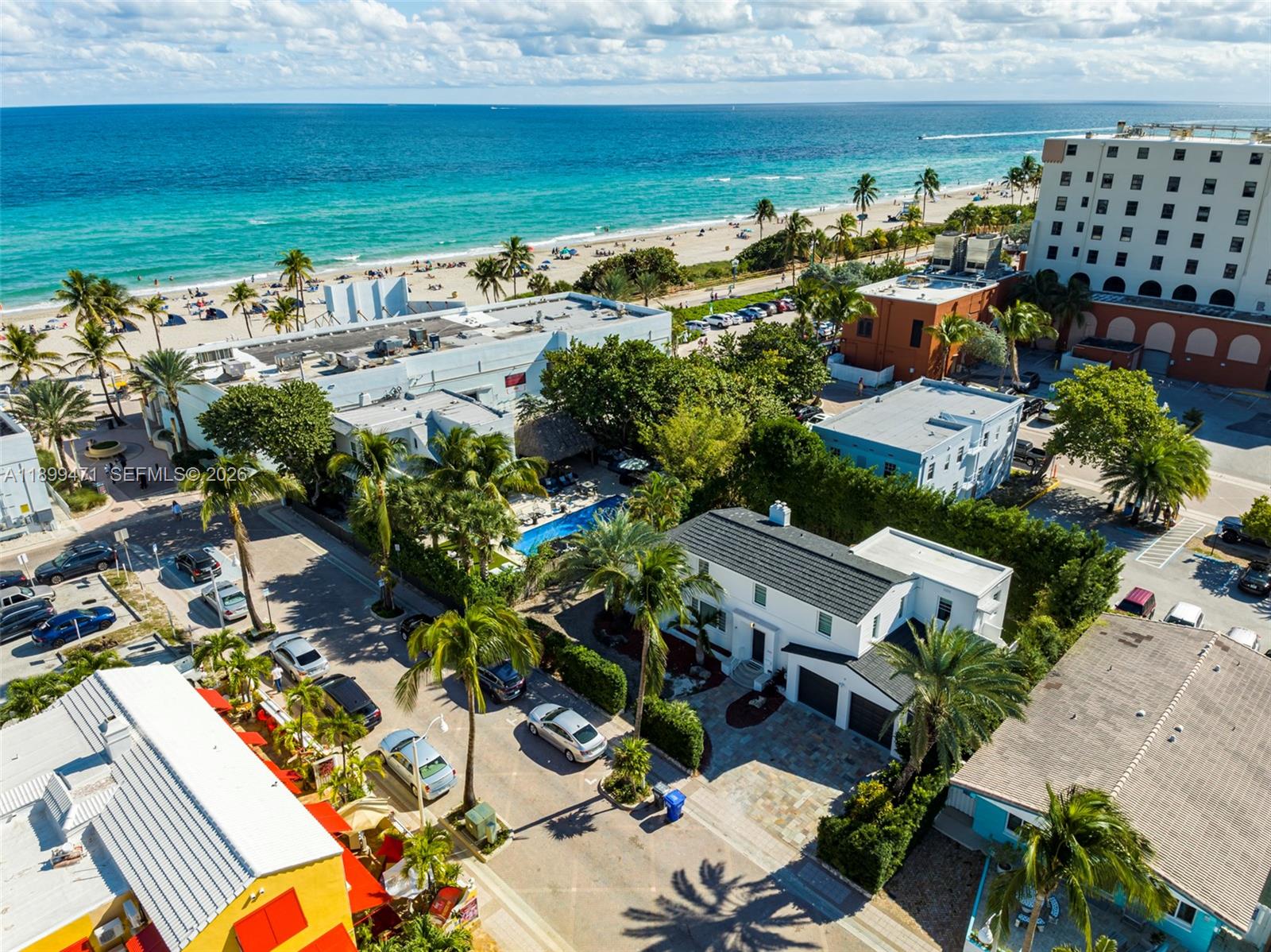 An aerial view shows a white house with a dark roof near a beach — 320 Polk St, Hollywood FL 33019, HOLLYWOOD, FL