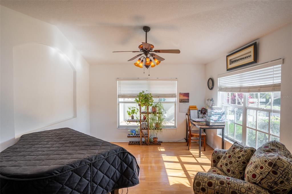 A bedroom features a bed, a desk, a patterned armchair, and a ceiling fan — 624 N LAKE BOULEVARD, TARPON SPRINGS, FL