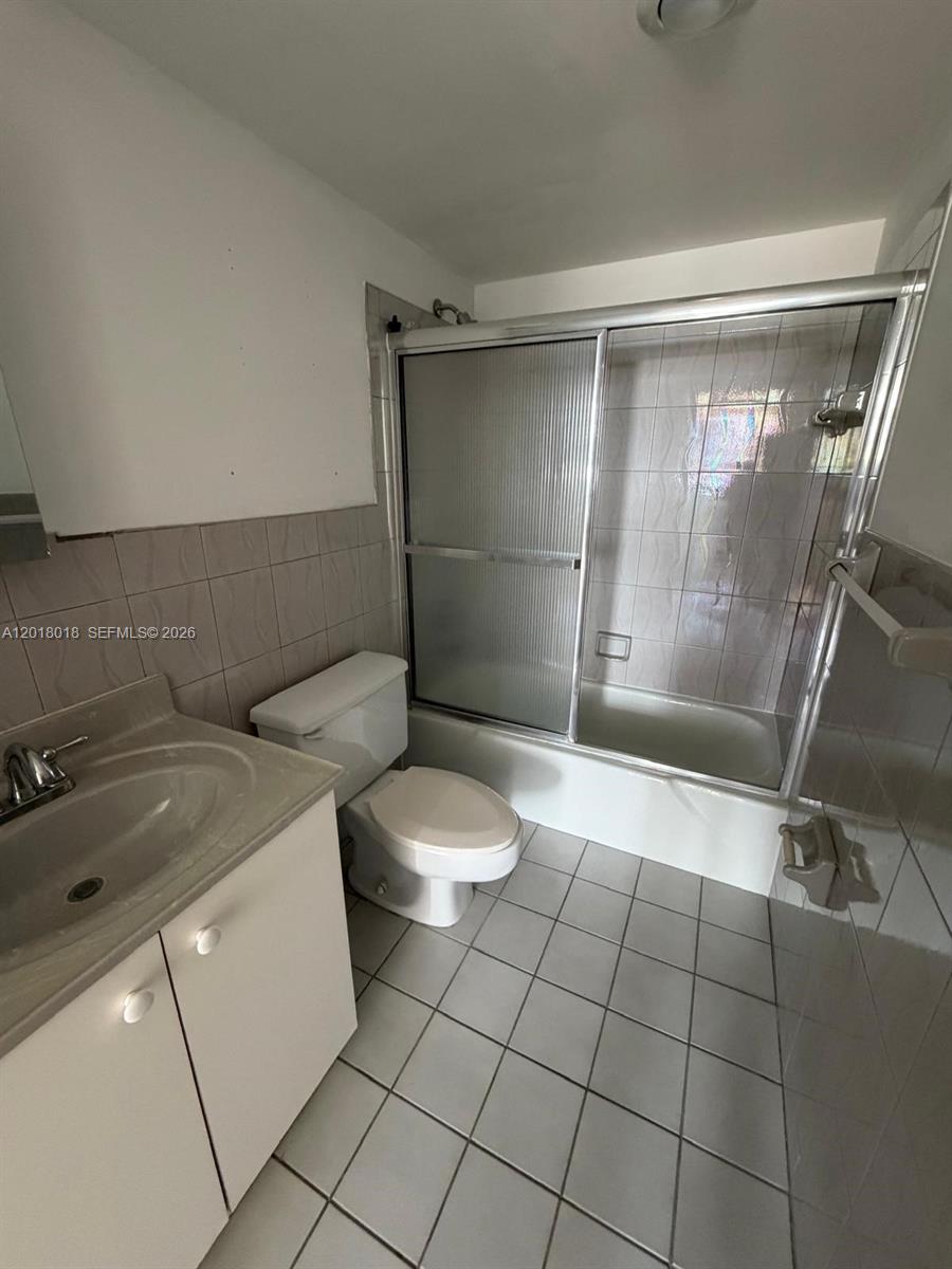 A bathroom features a vanity, a toilet, and a shower-tub combination with sliding glass doors — 1817 S Ocean Dr # 319, Hallandale Beach FL 33009, HALLANDALE BEACH, FL