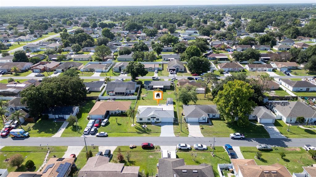An aerial view shows a suburban neighborhood with single-family homes and residential streets — 256 CRANBROOK DRIVE, KISSIMMEE, FL