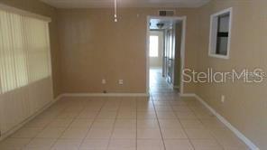 An interior view of a room with beige walls, tiled flooring, and a doorway — 700 E AIRPORT BOULEVARD UNIT B6, SANFORD, FL
