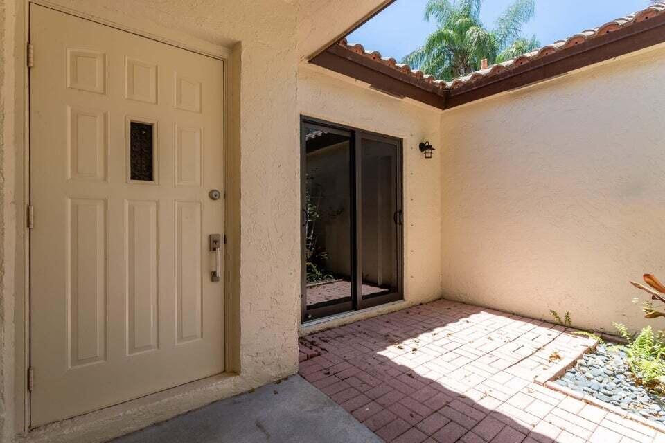 A beige front door and a sliding glass door open onto a brick-paved entryway — 3113 Kingswood Terrace, Boca Raton FL 33431, BOCA RATON, FL
