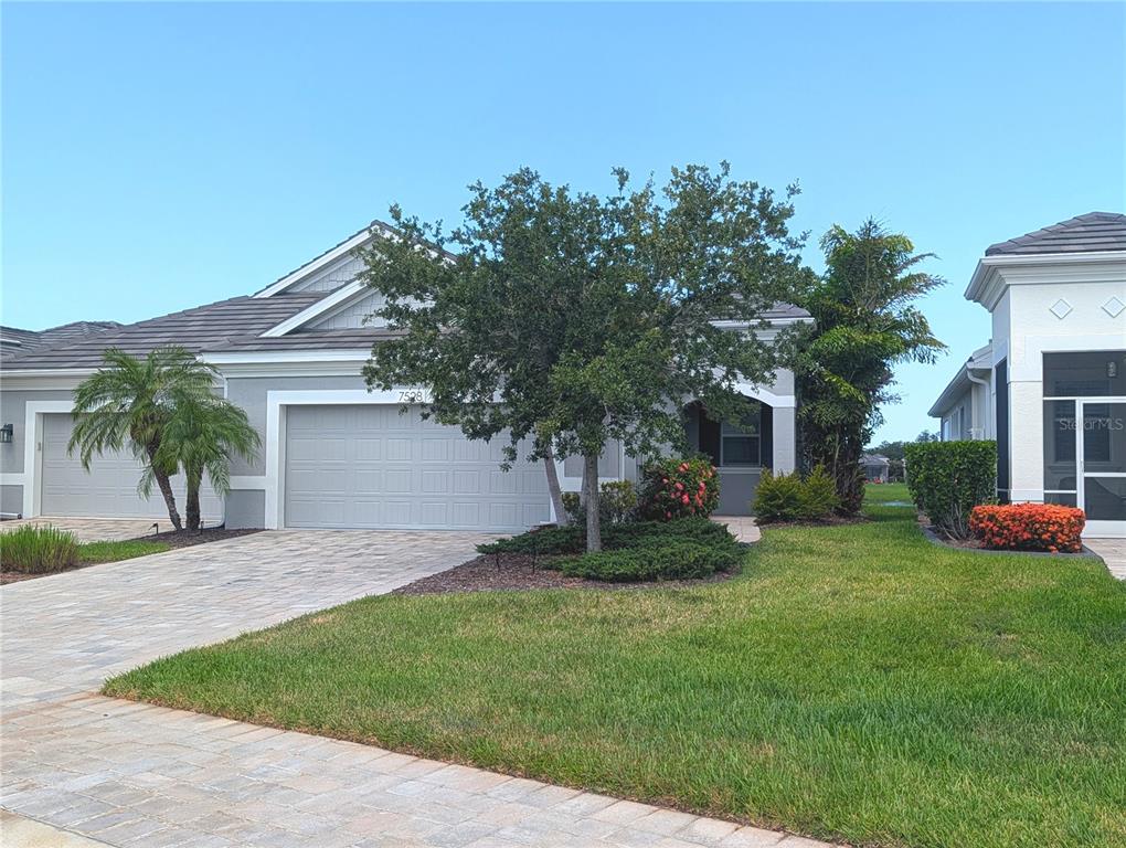 A single-story house with a gray exterior, a two-car garage, and a paved driveway — 7528 ALUMNI TRAIL, SARASOTA, FL