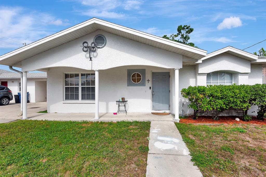 A single-story white house with a covered porch, a gray front door, and a lawn — 6528/ 6530 12TH STREET W, BRADENTON, FL